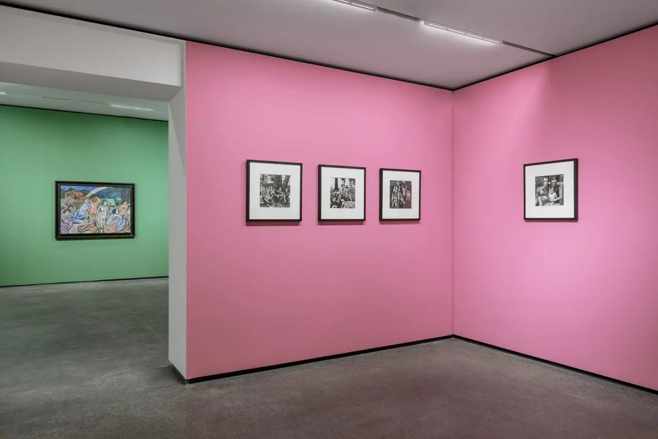 Exhibition rooms of an art show with coloured walls and framed works
